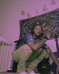 a man crouching in front of a guitar