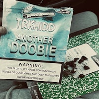 Another Doobie by TRKhidd Single Cover Art. Green Composition Notebook with Doobies Roaches Blunt Crumbs in Background. Ice Cold Looseleaf Gar Wrapper Parody.